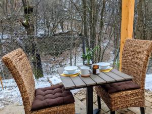 a wooden table with two chairs and a table with food on it at A Ház in Kismaros
