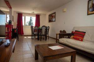 een woonkamer met een bank en een tafel bij DEPARTAMENTO CÉNTRICO CON VISTA AL LAGO in Bariloche