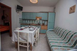 Una pequeña cocina con una mesa y un sofá. en Apartments in Rosolina Mare 25071, en Rosolina Mare 6 fotos más