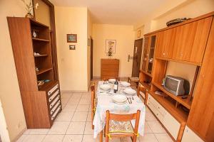 een eetkamer met een tafel en een tv bij Apartment in Rosolina Mare 25080 in Rosolina Mare