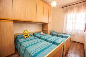 een slaapkamer met 2 aparte bedden en een knuffeldier op de bedden bij Apartment in Rosolina Mare 25080 in Rosolina Mare
