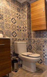 a bathroom with a toilet and blue and white tiles at Knysna Boutique Rooms in Peñíscola