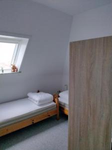 a bedroom with two beds and a window at Ferienwohnung 4 Haus Neptun Ideal für Familien mit Kindern in Büsum