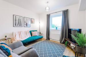 a living room with a blue couch and a window at Paladine Place Serviced Apartment Coventry in Coventry