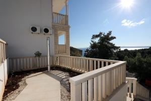 einen Balkon eines Hauses mit weißem Geländer in der Unterkunft Sea View Apartments in Selca