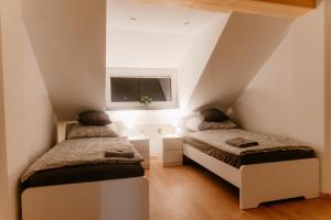 2 Betten in einem Dachzimmer mit Fenster in der Unterkunft Monteurzimmer Pavan, M2, Apartment for Workers Saarbrücken,Luxemburg,Überherrn-KEINE Ferienwohnung in Saarlouis + 18 Fotos