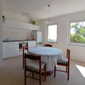 eine Küche mit einem Tisch und Stühlen im Zimmer in der Unterkunft Sea View Apartments in Selca