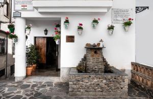 a white building with a fountain in a courtyard at tuGuest Carataunas Apartment II Alpujarra in Carataunas