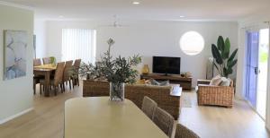 a living room with a table with a vase on it at Beaches 1 -LJHooker yamba in Yamba