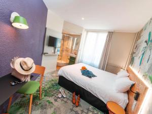 a bedroom with a bed and a hat on a table at ibis Styles Paris Boulogne Marcel Sembat in Boulogne-Billancourt