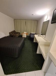 een hotelkamer met een bed en een bureau bij Cottonwood Motor Inn in Mildura