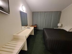 Habitación de hotel con cama y escritorio en Cottonwood Motor Inn, en Mildura