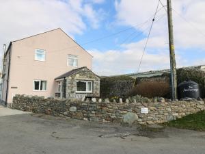a stone retaining wall in front of a house at The Anchorage in Llanrhyddlad