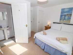 a bedroom with a white bed and a sink at The Anchorage in Llanrhyddlad