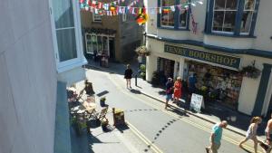 a group of people walking on a street in front of a store at "Sea Suite" Tenby in Tenby