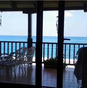 a view of the ocean from a porch with chairs at Dovas house in Chorefto