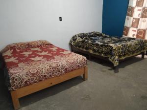 duas camas sentadas uma ao lado da outra num quarto em Aquetzali Kin Casa Privada con alberca em Cuautla, Morelos