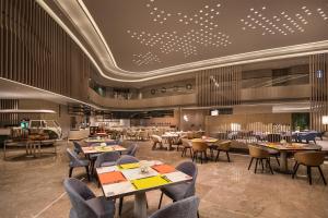 a restaurant with tables and chairs in a room at Holiday Inn - Nanjing South Station, an IHG Hotel in Nanjing