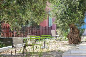 un groupe de chaises et de tables sous un arbre dans l'établissement Villas Thassos, à Limenaria