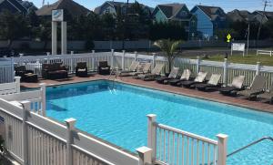 a large swimming pool with lounge chairs next to it at Dunes by the Ocean in Point Pleasant Beach