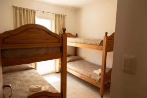 a bedroom with two bunk beds and a window at 5ta Bajada Las Grutas in Las Grutas