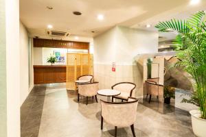 ein Wartezimmer mit Tischen, Stühlen und Pflanzen in der Unterkunft Hotel Liberty Matsuyama (Adult Only) in Matsuyama
