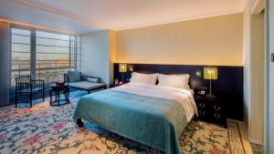 a hotel room with a bed and a balcony at Grand Hotel Beijing Forbidden City in Beijing