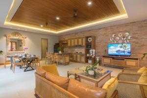 - un salon avec un canapé et une salle à manger dans l'établissement Villa Daun 1 Canggu by Premier Hospitality Asia, à Canggu