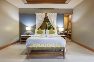 Schlafzimmer mit einem großen Bett und einer Bank in der Unterkunft Villa Daun Canggu by Premier Hospitality Asia in Canggu + 94 Fotos