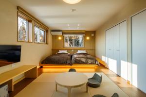 - une chambre avec un lit et une table dans l'établissement Aoni Sanso, à Senboku