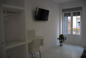 a white room with a tv on a wall at Hostal Madrid Star in Madrid