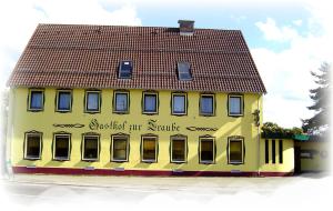 a large yellow building with a red roof at Gasthof Hotel Traube in Oberndorf