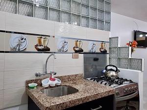 a small kitchen with a sink and a stove at Cusco Magico 6 - Mini Departamento Santa Ursula in Cusco