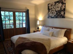 um quarto com uma cama grande e uma janela em Little Chelsea em Moss Vale