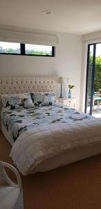 a bedroom with a large bed with a large window at Beachfront Bliss in Ohope Beach