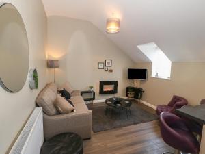 a living room with a couch and a table at Tan Bryn 2 in Aberdaron