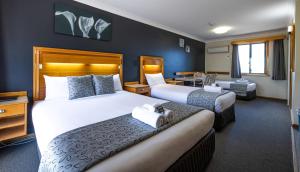 a hotel room with two beds and a desk at Bathurst Gold Panner in Bathurst