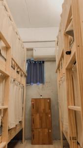 That day Hostel 那天旅宿 في Lanyu: غرفة بأرفف خشبية وستارة زرقاء