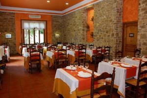 a dining room with white tables and chairs and brick walls at Hotel Balneari de Vallfogona de Riucorb in Vallfogona de Riucorb