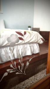 a bed with a white blanket with flowers on it at 赤嵌厝Child Come Home-依人數床位數計價開放房型 in Tainan