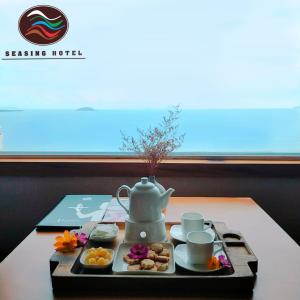 uma bandeja de comida com uma chaleira de chá sobre uma mesa em Seasing Boutique Hotel em Nha Trang