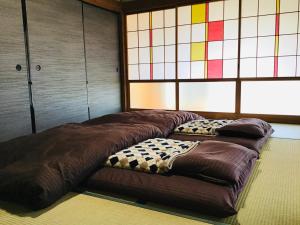 two large beds in a room with stained glass windows at 古民家宿　寝つきいいキツネ in Shimanto