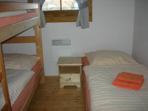 a bedroom with two bunk beds and a small table at Drevenica pod smrekom in Terchová