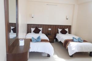 Ένα ή περισσότερα κρεβάτια σε δωμάτιο στο Pokhara Tourist Home