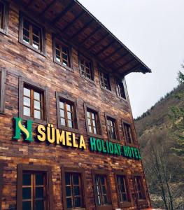 SÜMELA HOLİDAY HOTEL في ماتشكا: مبنى خشبي عليه لافته