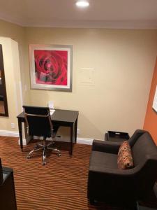 a living room with a desk and a couch and a chair at Convention Center Inn & Suites in San Jose