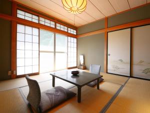 Una sala de estar con mesa y sillas y ventanas. en Yama no Yado Meiji Onsen, en Chino 67 fotos más