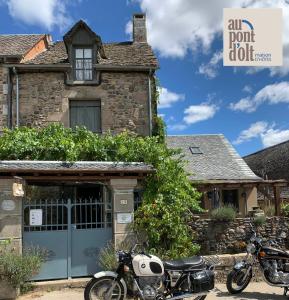 two motorcycles parked in front of a house at Au Pont d’Olt in Saint-Côme-dʼOlt