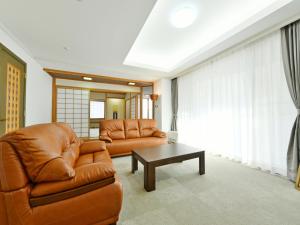 sala de estar con sofá y mesa en Hostel PLEASURE MARUYAMA, en Sapporo