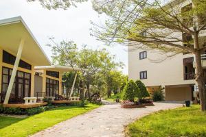 un cortile di un edificio con panchine e alberi di Lazi Beach Resort a La Gi